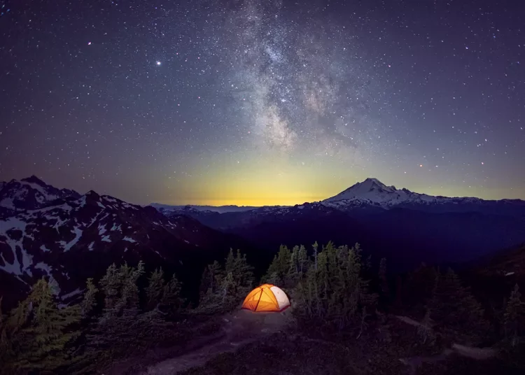 A tent is under the Milky Way on the top of a mountain, Washington, US